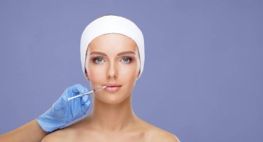 Genç bir kadının güzel yüzüne iğne yapan bir doktor. Estetik ameliyat konsepti.