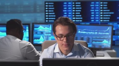 Ofiste çalışan çeşitli simsarlar çalışma istasyonu ve analiz teknolojisi kullanıyor. Profesyonel tüccarların işyeri. Küresel finans piyasaları, iş dünyası, döviz kurları ve bankacılık kavramları.