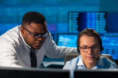 Komisyonculardan oluşan bir ekip, çalışma istasyonu ve analiz teknolojisini kullanarak ofiste çalışıyor. Profesyonel tüccarların işyeri. Küresel finans piyasaları, iş dünyası, döviz kurları ve bankacılık kavramları.