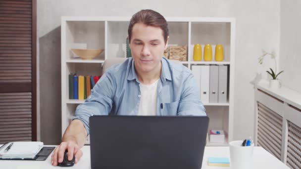 Lieu de travail du travailleur indépendant au bureau à domicile. Le jeune homme travaille sur ordinateur. Concept d'emploi à distance. — Video