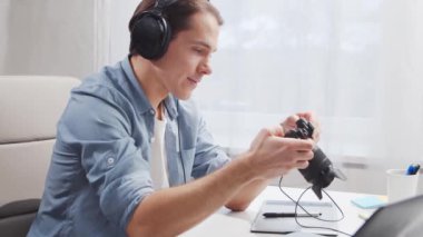 Ev ofisinde serbest fotoğrafçı işyeri. Genç adam bilgisayar, grafik tablet ve kamera kullanıyor. Uzak görev konsepti.