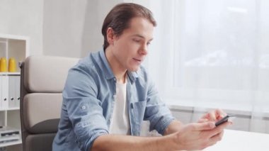 Serbest çalışanların çalıştığı yer ev ofisinde akıllı telefonları kullanıyor. Uzak görev konsepti.