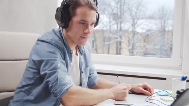 Pracoviště na volné noze v domácí kanceláři. Mladý muž pracuje s počítačem a grafickým tabletem. Koncept vzdálené úlohy. — Stock video