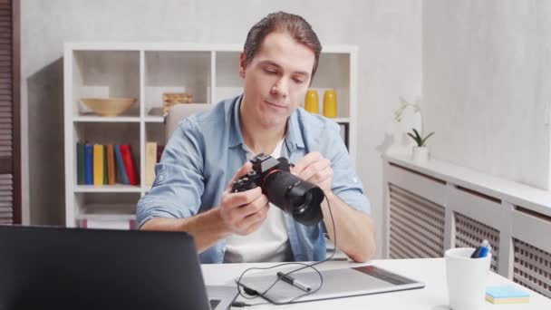 Kancelář fotografa na volné noze. Mladý muž pracuje s počítačem, grafickým tabletem a kamerou. Koncept vzdálené úlohy. — Stock video
