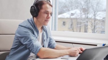 Ev ofisinde serbest tasarımcı işyeri. Genç adam bilgisayar ve grafik tableti kullanıyor. Uzak görev konsepti.