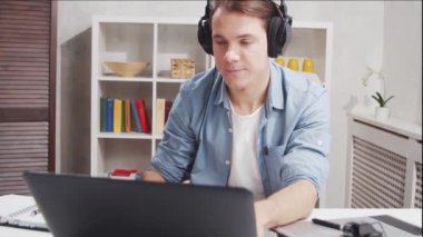 Ev ofisinde serbest tasarımcı işyeri. Genç adam bilgisayar ve grafik tableti kullanıyor. Uzak görev konsepti.