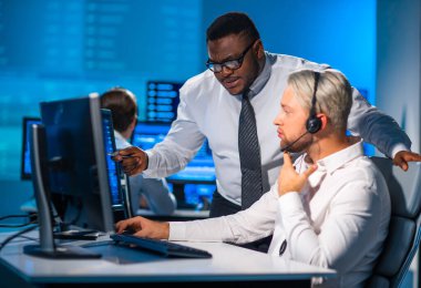 Komisyonculardan oluşan bir ekip, çalışma istasyonu ve analiz teknolojisini kullanarak ofiste çalışıyor. Profesyonel tüccarların işyeri. Küresel finans piyasaları, iş dünyası, döviz kurları ve bankacılık kavramları.