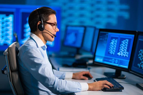 El trabajador del centro de llamadas está hablando con el cliente por auriculares. Lugar de trabajo del operador de apoyo profesional en el cargo. — Foto de Stock