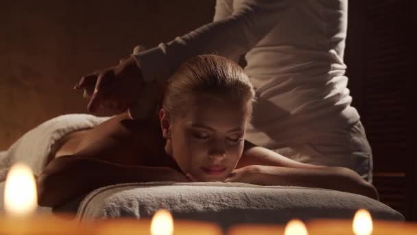 Giovane e bella donna ottiene la terapia di massaggio con le palle alle erbe nel salone termale. Stile di vita sano e concetto di cura del corpo. — Video Stock