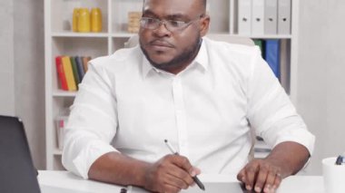 Ev ofisinde serbest tasarımcı işyeri. Genç Afro-Amerikalı bir adam bilgisayar ve grafik tableti kullanıyor. Uzak görev konsepti.