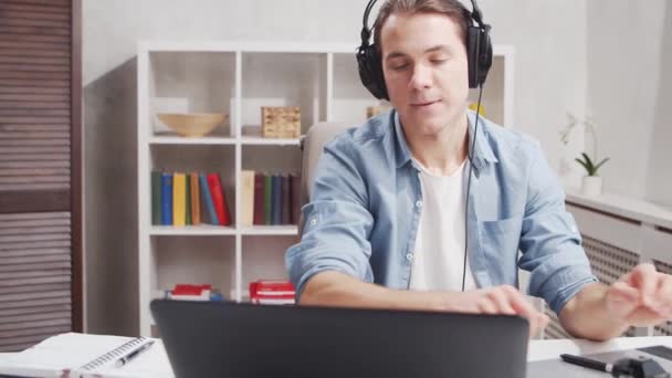 Ev ofisinde serbest tasarımcı işyeri. Genç adam bilgisayar ve grafik tableti kullanıyor. Uzak görev konsepti. — Stok video