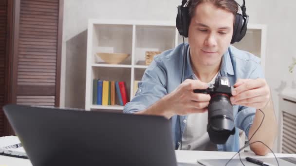 프리랜서 사진사 사무실에서 일 해요. 젊은 남자는 컴퓨터, 그래픽 태블릿, 카메라를 사용하여 일 합니다. 원격 직업 개념. — 비디오