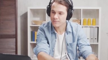 Ev ofisinde serbest tasarımcı işyeri. Genç adam bilgisayar ve grafik tableti kullanıyor. Uzak görev konsepti.