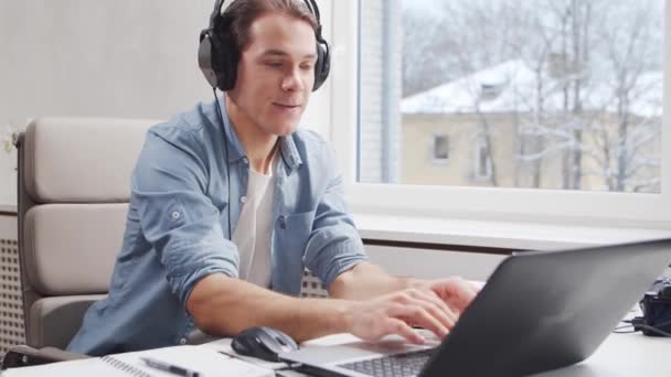 Pracoviště na volné noze nebo náhlé v domácí kanceláři. Mladý muž pracuje s počítačem. Koncept vzdálené úlohy. — Stock video