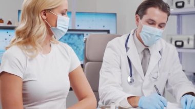 Doktor şırınga ve şırınga kullanarak koronavirüs aşısı yapıyor. Hastane ofisinde profesyonel tıp çalışanı ve hasta. Aşı ve güvenlik kavramı.