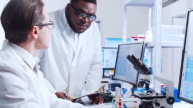 Profesyonel bilim adamları modern bir bilimsel araştırma laboratuvarında bir aşı üzerinde çalışıyorlar. Genetik mühendisliği işyeri. Fütürist teknoloji ve bilim konsepti.