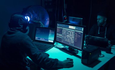 Bilgisayar ve dizüstü bilgisayar kullanarak virüs fidye virüsü kodlayan aranan hackerlar. Siber saldırı, sistem kırma ve kötü amaçlı yazılım kavramı.