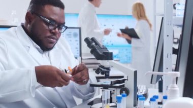 Profesyonel bilim adamları modern bir bilimsel araştırma laboratuvarında bir aşı üzerinde çalışıyorlar. Genetik mühendisliği işyeri. Fütürist teknoloji ve bilim konsepti.