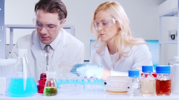 El equipo profesional de científicos está trabajando en una vacuna en un moderno laboratorio de investigación científica. Trabajo de ingeniero genético. Tecnología futurista y concepto de ciencia. — Vídeo de stock