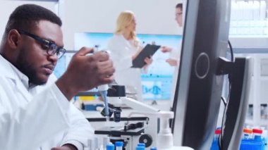 Profesyonel bilim adamları modern bir bilimsel araştırma laboratuvarında bir aşı üzerinde çalışıyorlar. Genetik mühendisliği işyeri. Fütürist teknoloji ve bilim konsepti.