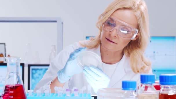 Professional female scientist is working on a vaccine in a modern scientific research laboratory. Genetic engineer workplace. Futuristic technology and science concept. — Stock Video