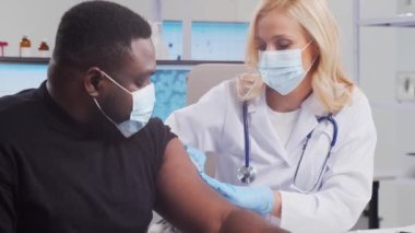 Doktor şırınga ve şırınga kullanarak koronavirüs aşısı yapıyor. Hastane ofisinde profesyonel tıp çalışanı ve hasta. Aşı ve güvenlik kavramı.