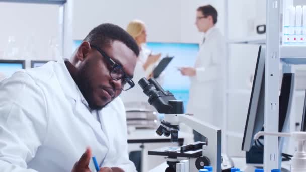 A equipe profissional de cientistas está trabalhando em uma vacina em um moderno laboratório de pesquisa científica. Engenheiro genético no trabalho. Conceito de tecnologia e ciência futurista. — Vídeo de Stock