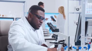 Profesyonel bilim adamları modern bir bilimsel araştırma laboratuvarında bir aşı üzerinde çalışıyorlar. Genetik mühendisliği işyeri. Fütürist teknoloji ve bilim konsepti.