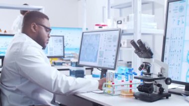 Profesyonel Afro-Amerikan bilim adamı modern bir bilimsel araştırma laboratuvarında aşı üzerinde çalışıyor. Genetik mühendisliği işyeri. Fütürist teknoloji ve bilim konsepti.