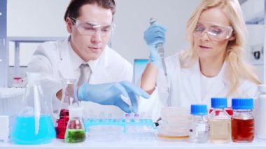 Profesyonel bilim adamları modern bir bilimsel araştırma laboratuvarında bir aşı üzerinde çalışıyorlar. Genetik mühendisliği işyeri. Fütürist teknoloji ve bilim konsepti.