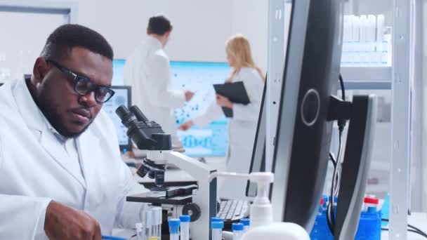 A tudósok profi csapata egy vakcinán dolgozik egy modern tudományos kutató laboratóriumban. Genetikai mérnöki munkahely. Futurisztikus technológiai és tudományos koncepció. — Stock videók