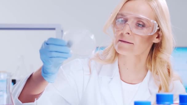 Professional female scientist is working on a vaccine in a modern scientific research laboratory. Genetic engineer workplace. Futuristic technology and science concept. — Stock Video