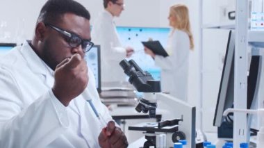 Profesyonel bilim adamları modern bir bilimsel araştırma laboratuvarında bir aşı üzerinde çalışıyorlar. Genetik mühendisliği işyeri. Fütürist teknoloji ve bilim konsepti.