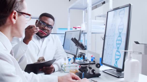A tudósok profi csapata egy vakcinán dolgozik egy modern tudományos kutató laboratóriumban. Genetikai mérnöki munkahely. Futurisztikus technológiai és tudományos koncepció. — Stock videók