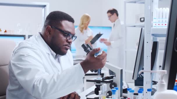 A equipe profissional de cientistas está trabalhando em uma vacina em um moderno laboratório de pesquisa científica. Engenheiro genético no trabalho. Conceito de tecnologia e ciência futurista. — Vídeo de Stock