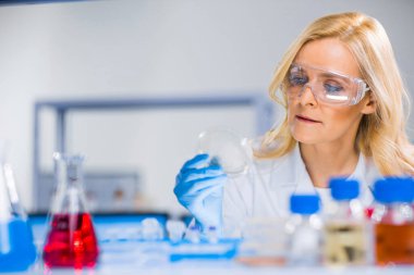 Profesyonel kadın bilim adamı modern bir bilimsel araştırma laboratuvarında aşı üzerinde çalışıyor. Genetik mühendisliği işyeri. Gelecekteki teknoloji ve bilim.