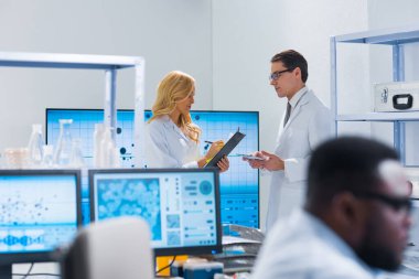 Profesyonel bilim adamları modern bir bilimsel araştırma laboratuvarında bir aşı üzerinde çalışıyorlar. Genetik mühendisliği işyeri. Gelecekteki teknoloji ve bilim.