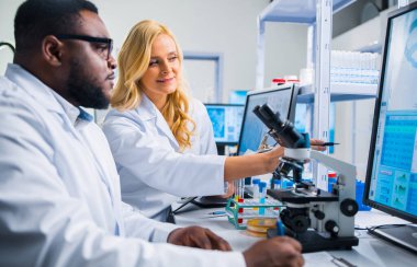 Profesyonel bilim adamları modern bir bilimsel araştırma laboratuvarında bir aşı üzerinde çalışıyorlar. Genetik mühendisliği işyeri. Gelecekteki teknoloji ve bilim.