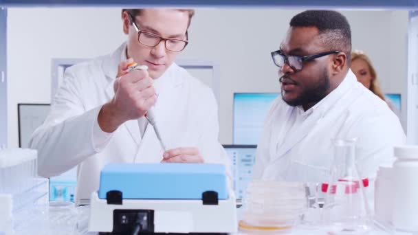 科学者の専門チームは、現代の科学研究所でワクチンに取り組んでいます。遺伝子工学の職場だ。未来技術と科学の概念. — ストック動画