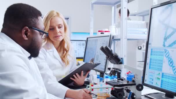 Professioneel team van wetenschappers werkt aan een vaccin in een modern wetenschappelijk onderzoekslaboratorium. Genetische ingenieur werkplek. Futuristische technologie en wetenschapsconcept. — Stockvideo