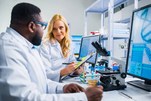 A tudósok profi csapata egy vakcinán dolgozik egy modern tudományos kutató laboratóriumban. Genetikai mérnöki munkahely. Jövőbeli technológia és tudomány. — Stock Fotó