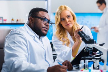Profesyonel bilim adamları modern bir bilimsel araştırma laboratuvarında bir aşı üzerinde çalışıyorlar. Genetik mühendisliği işyeri. Gelecekteki teknoloji ve bilim.