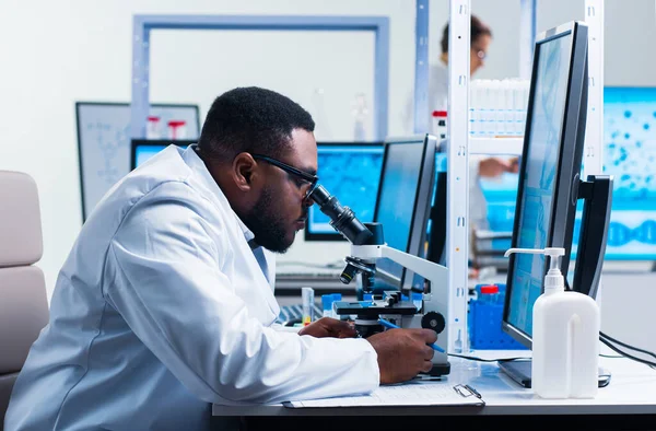 Profesjonalny afroamerykański naukowiec pracuje nad szczepionką w nowoczesnym laboratorium naukowym. Miejsce pracy inżyniera genetycznego. Przyszłe technologie i nauka. — Zdjęcie stockowe