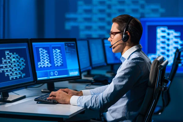 Le préposé du centre d'appels parle avec le client par casque. Lieu de travail de l'opérateur de soutien professionnel au bureau. — Photo