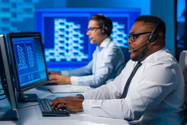 Call-Center-Mitarbeiter sprechen per Headset mit dem Kunden. Arbeitsplatz des afrikanisch-amerikanischen Supportbetreibers. — Stockfoto