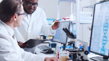 Profesyonel bilim adamları modern bir bilimsel araştırma laboratuvarında bir aşı üzerinde çalışıyorlar. Genetik mühendisliği işyeri. Fütürist teknoloji ve bilim konsepti.