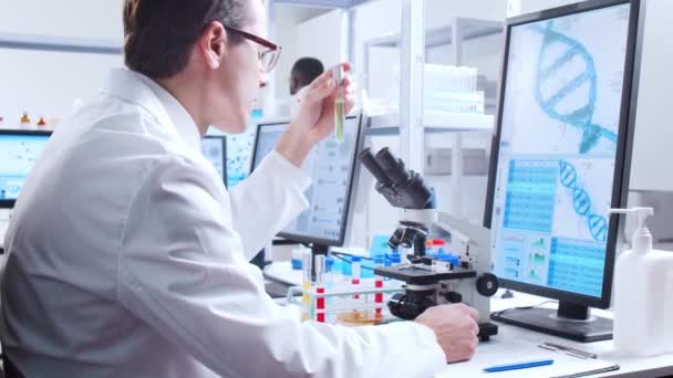 Professionell forskare arbetar med ett vaccin i ett modernt vetenskapligt forskningslaboratorium. Genetisk ingenjör på arbetsplatsen. Futuristisk teknik och vetenskapskoncept. — Stockvideo