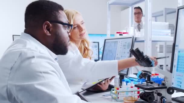 Un team di scienziati professionisti sta lavorando su un vaccino in un moderno laboratorio di ricerca scientifica. Ingegnere genetico posto di lavoro. Tecnologia futuristica e concetto di scienza. — Video Stock