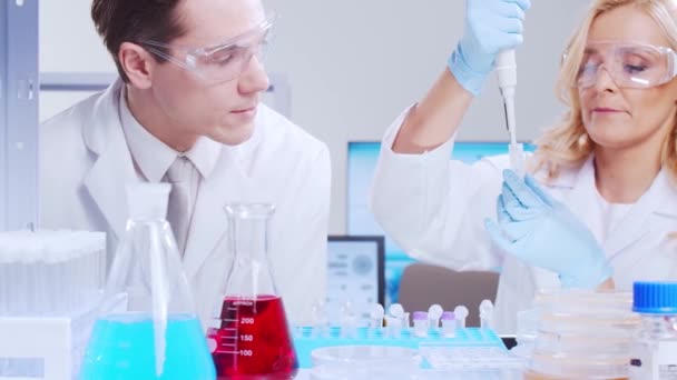 科学者の専門チームは、現代の科学研究所でワクチンに取り組んでいます。遺伝子工学の職場だ。未来技術と科学の概念. — ストック動画