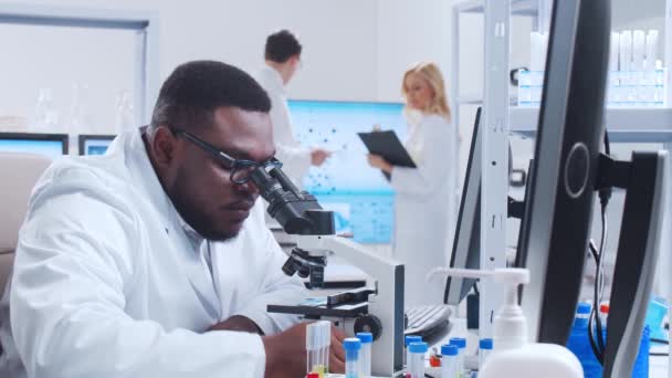 A equipe profissional de cientistas está trabalhando em uma vacina em um moderno laboratório de pesquisa científica. Engenheiro genético no trabalho. Conceito de tecnologia e ciência futurista. — Vídeo de Stock